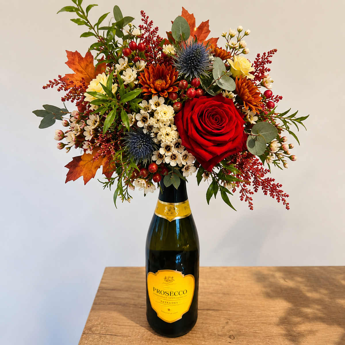 Prosecco bouquet with red rose and autumn foliage